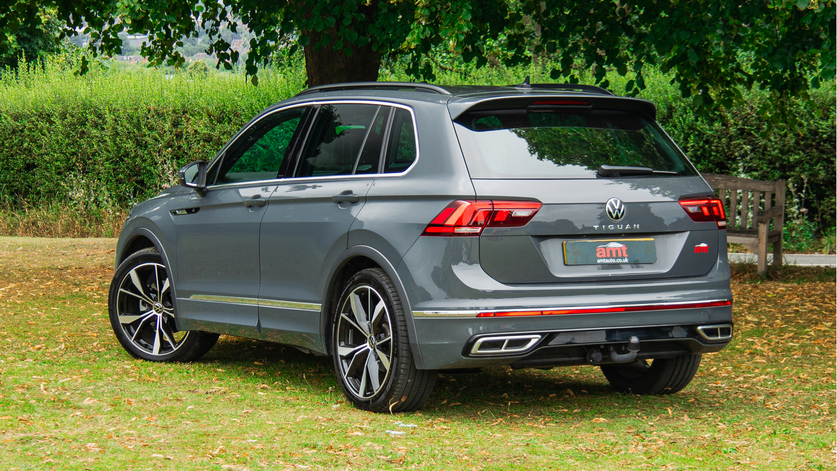 Rear view of a grey VW Tiguan parked under trees, featured in AMT’s UK VW Tiguan lease deals for personal or business use.