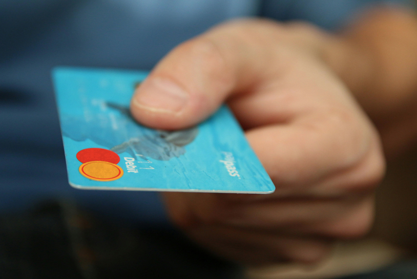 An image of a person holding a debit card
