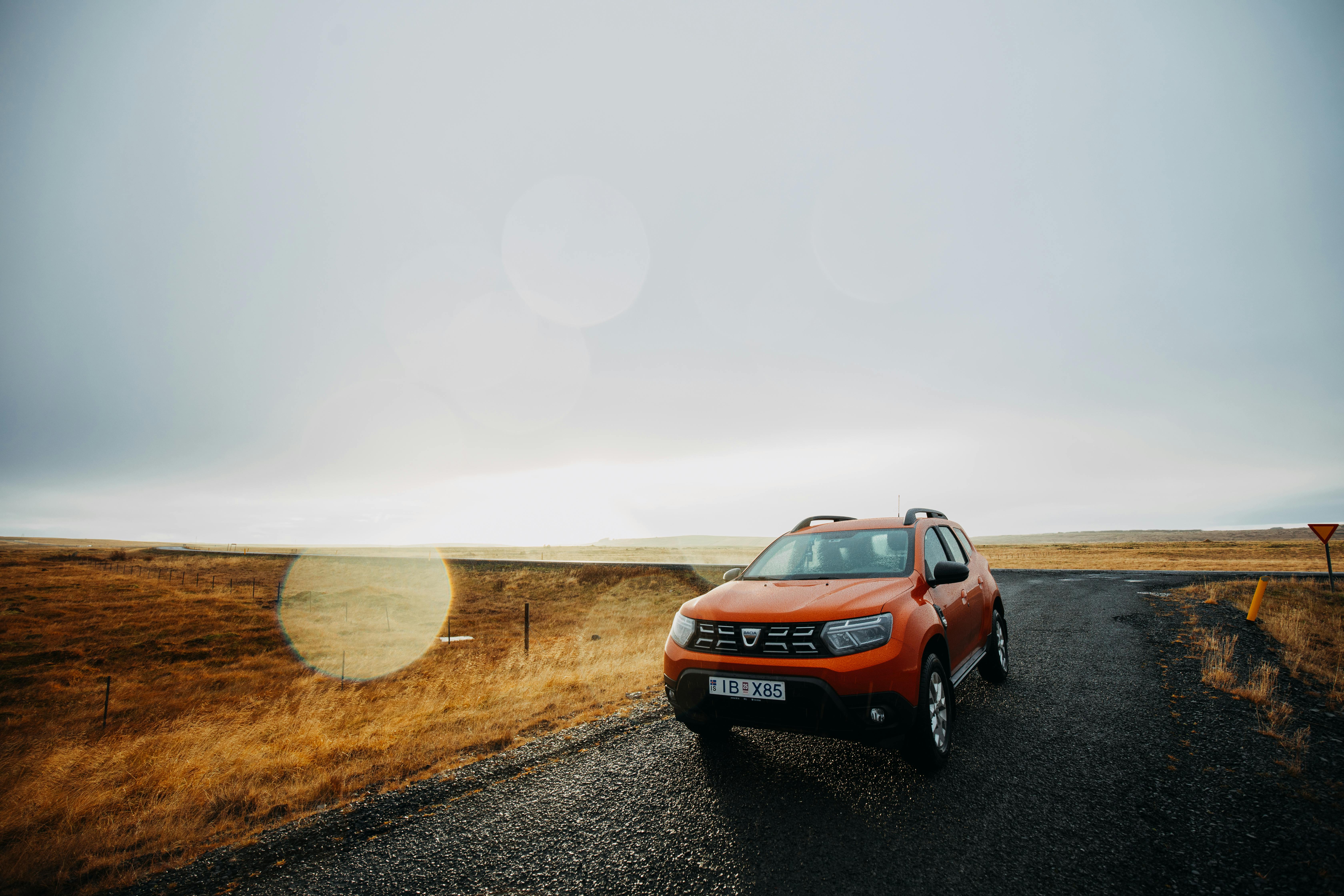 A Dacia Duster driving through a rough, dirt road, highlighting its practical design and reliable off-road performance. The vehicle features a sturdy build, ample ground clearance, and rugged tyres, making it an excellent choice for tackling various terrains while offering affordability and versatility.
