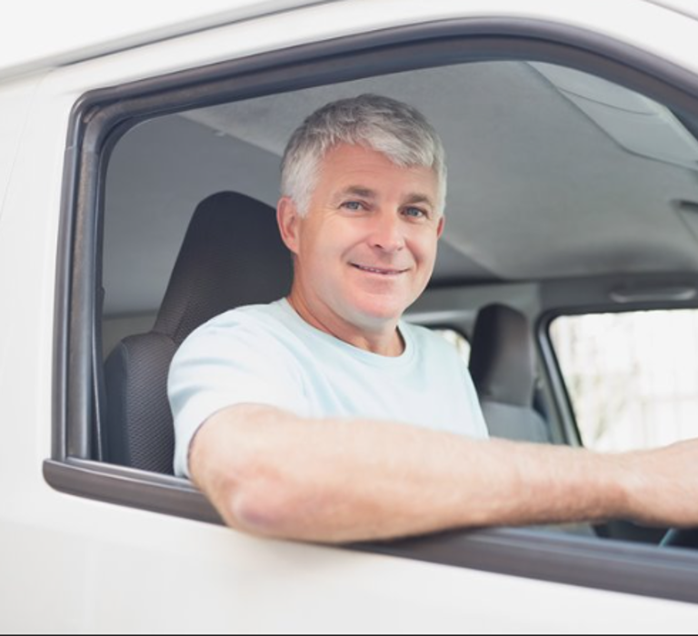 A picture of a man sat in the driving seat of a van