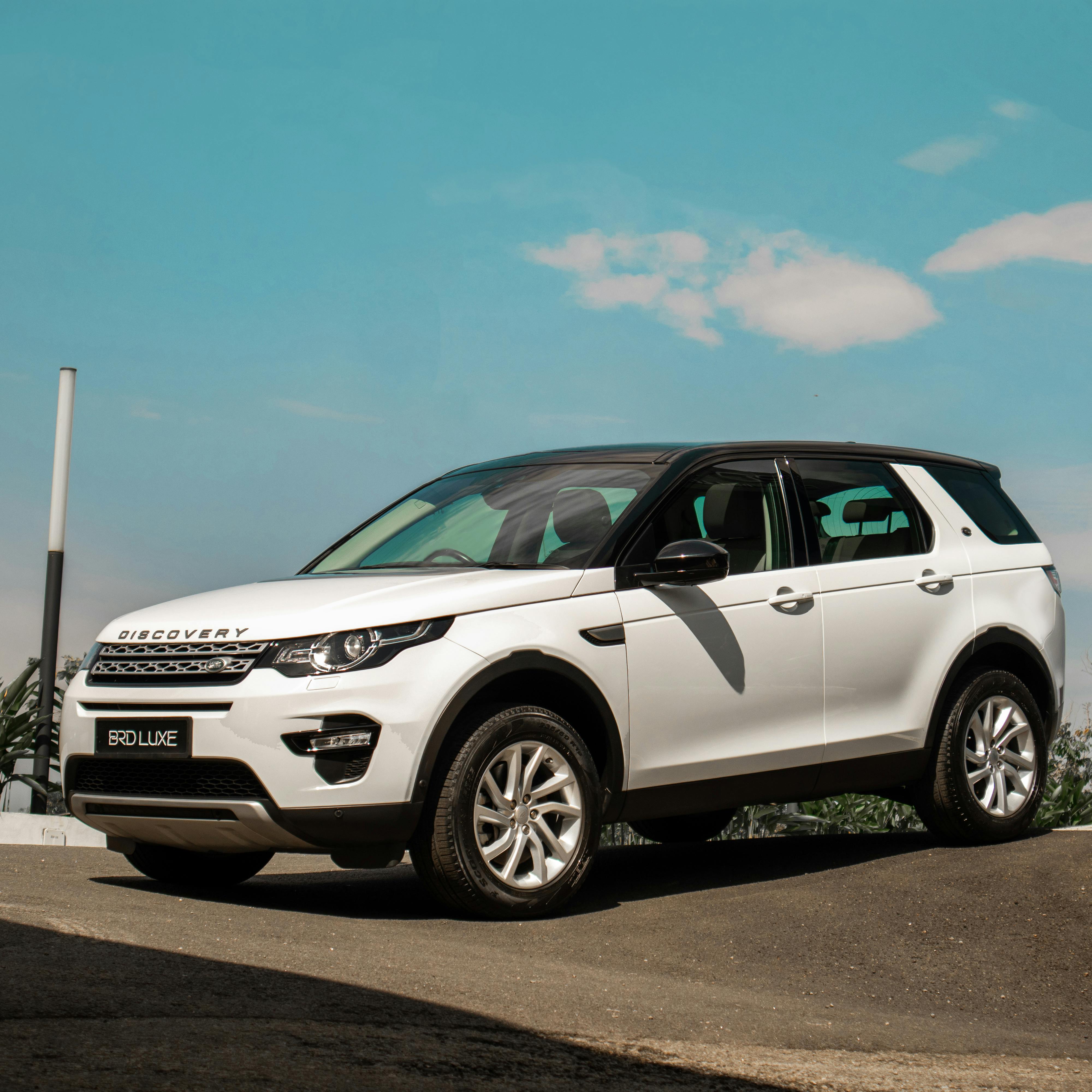 A Land Rover Discovery traversing a rugged, muddy trail, showcasing its blend of luxury and off-road prowess. The vehicle features sleek lines, a high ground clearance, and sophisticated design elements, demonstrating its capability to handle tough terrains while providing a comfortable and stylish ride.