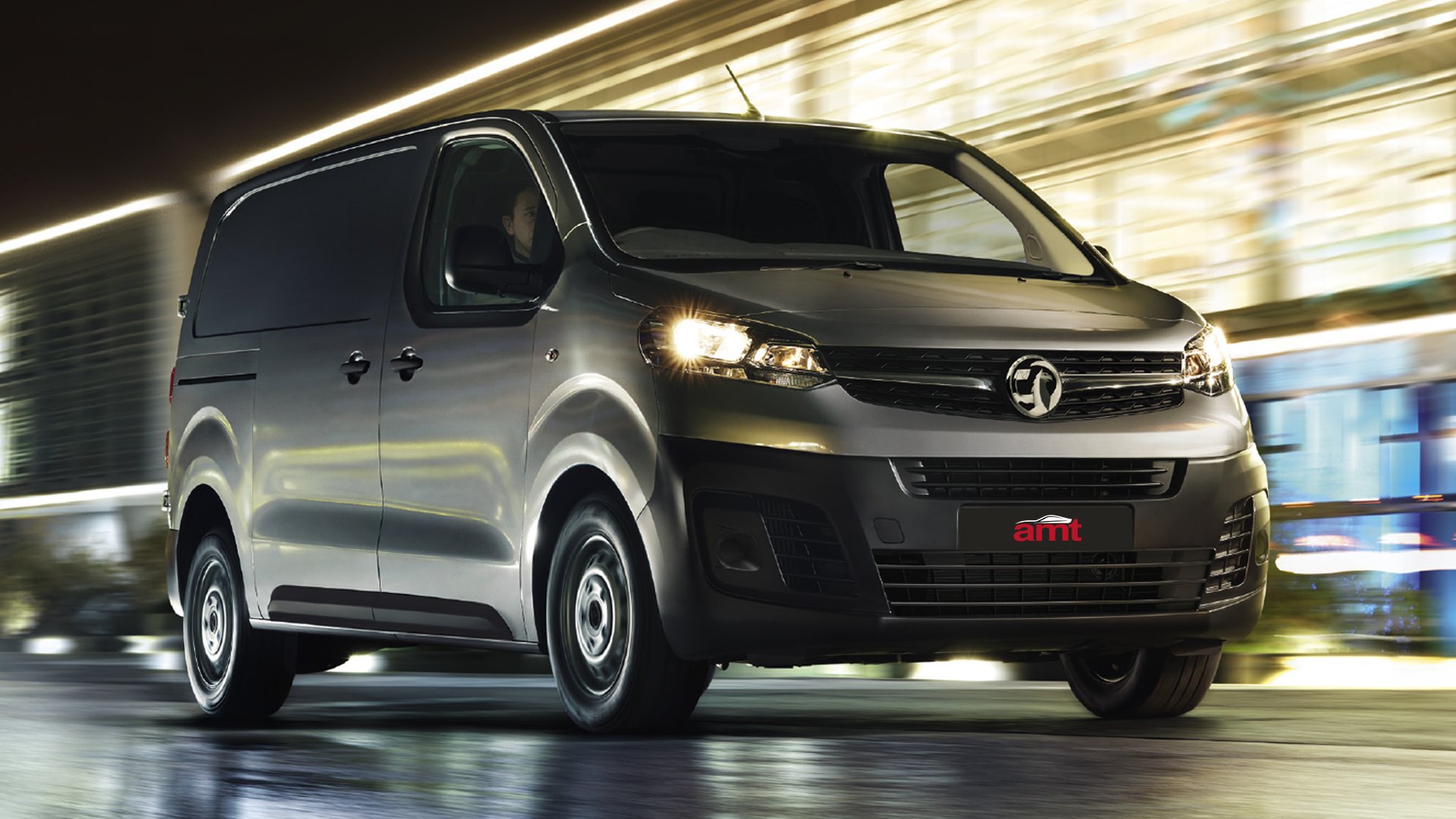 Vauxhall Vivaro van driving through a city at night, highlighting its sleek design and commercial leasing appeal.