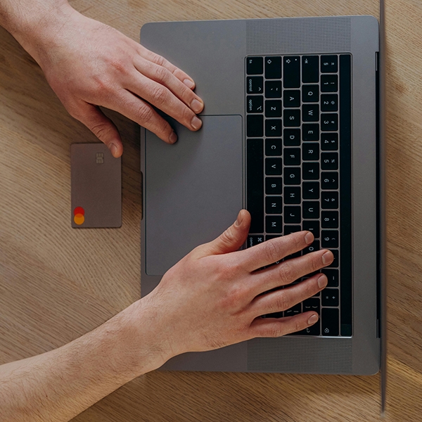 Person with bank card on grey laptop