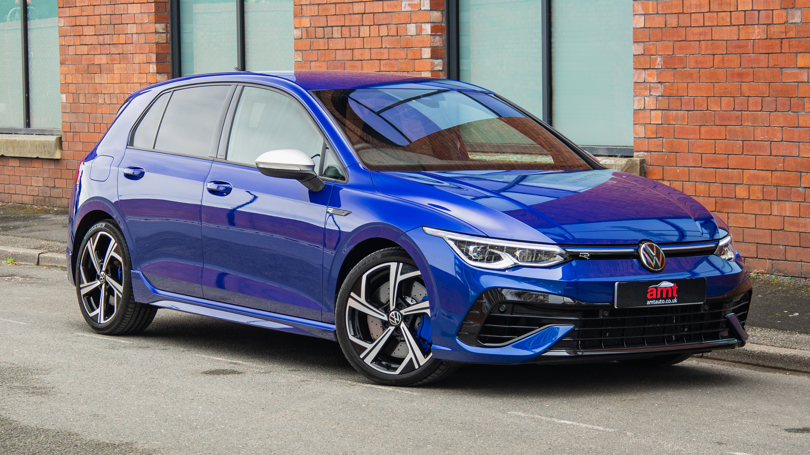 VW Golf R in Lapiz Blue parked on street, featured in AMT’s UK VW lease deals with sporty styling and sharp design.