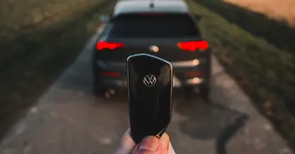 An image of a Volkswagen Golf and a person holding the car key up