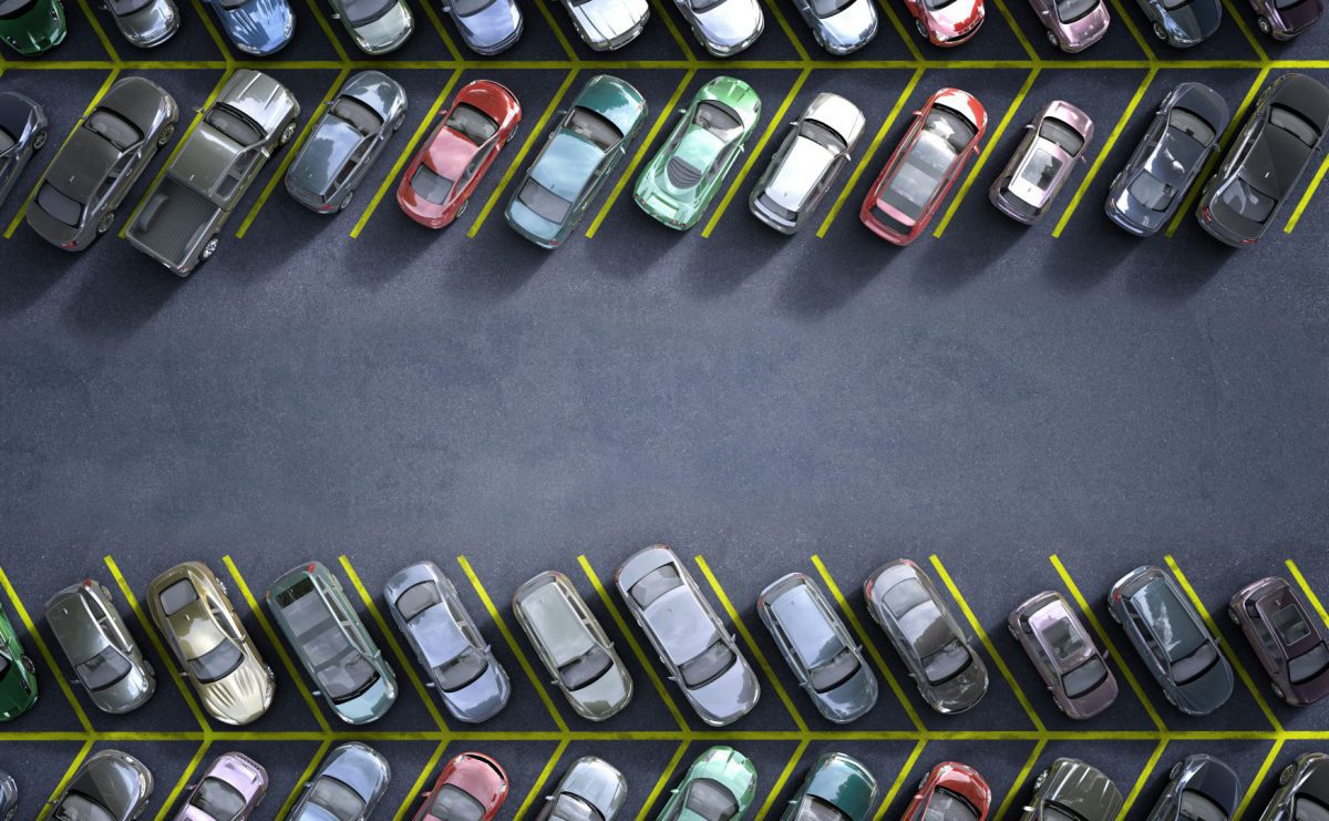 Aerial view of a crowded car park showing multiple parked vehicles in designated bays.