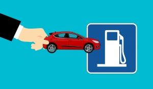 illustration of a person holding a red car near a fuel pump