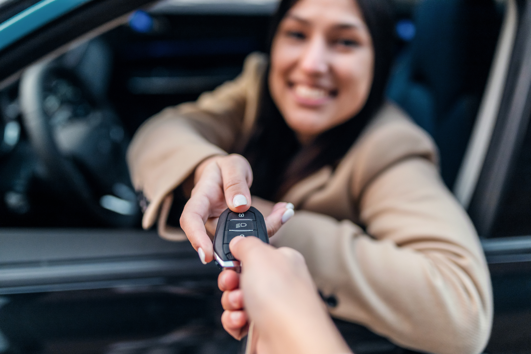 lady being handed car keys through car window