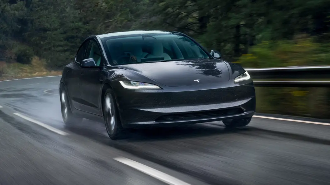 An image of the Tesla Model 3 driving in the rain.