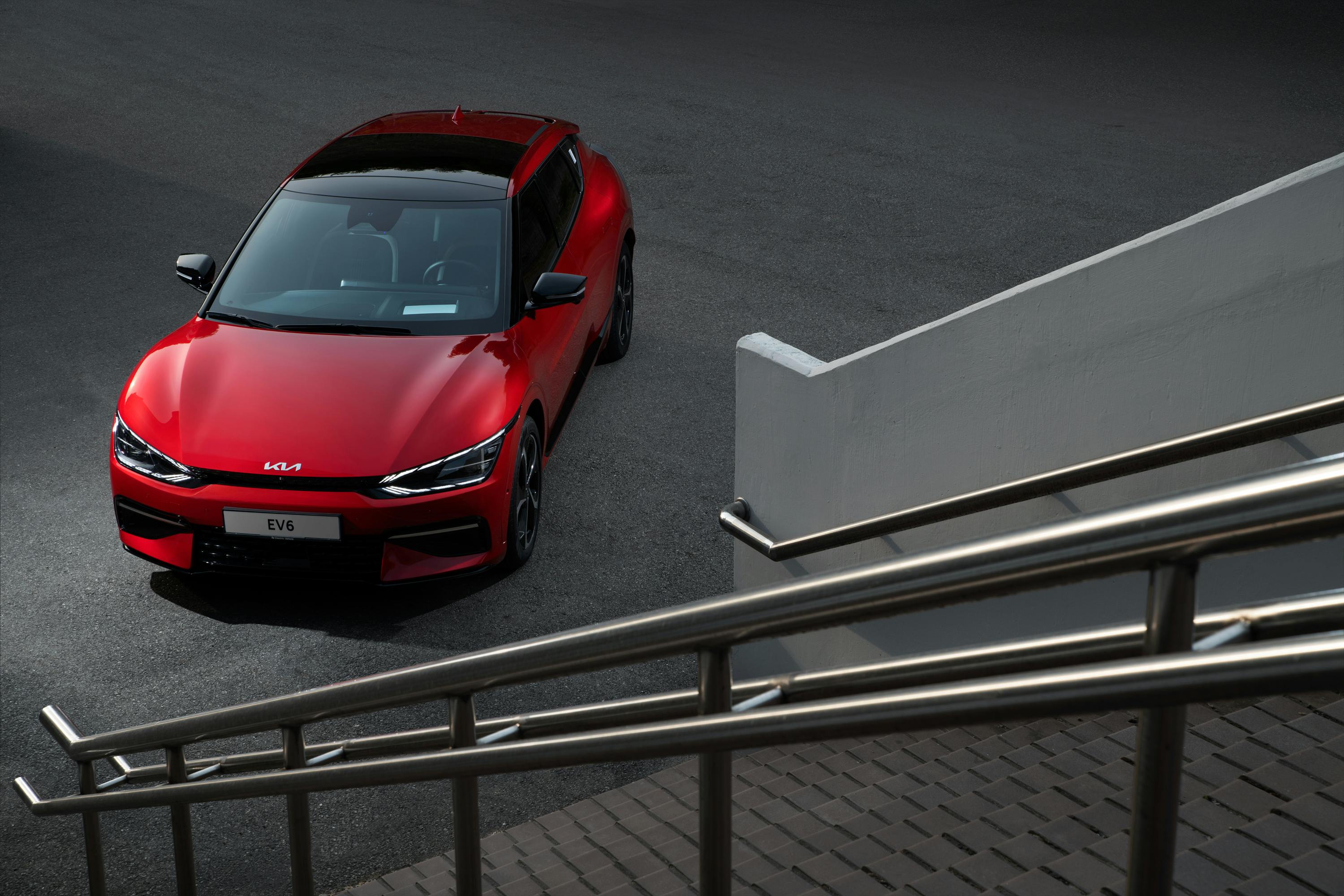 Interior view of a red Kia car with self-driving technology, featuring a sleek dashboard and comfortable black seats.