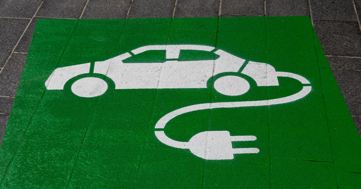 An image showing an electric car charging logo on the ground