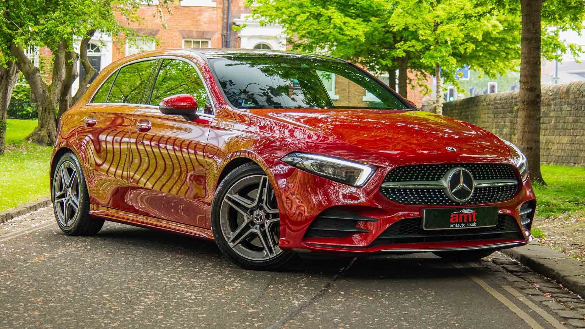 Red Mercedes-Benz A-Class hatchback parked under trees – affordable lease deal from AMT Auto