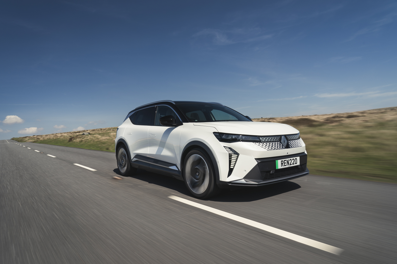 The Renault Scenic E-Tech driving down a country road. 