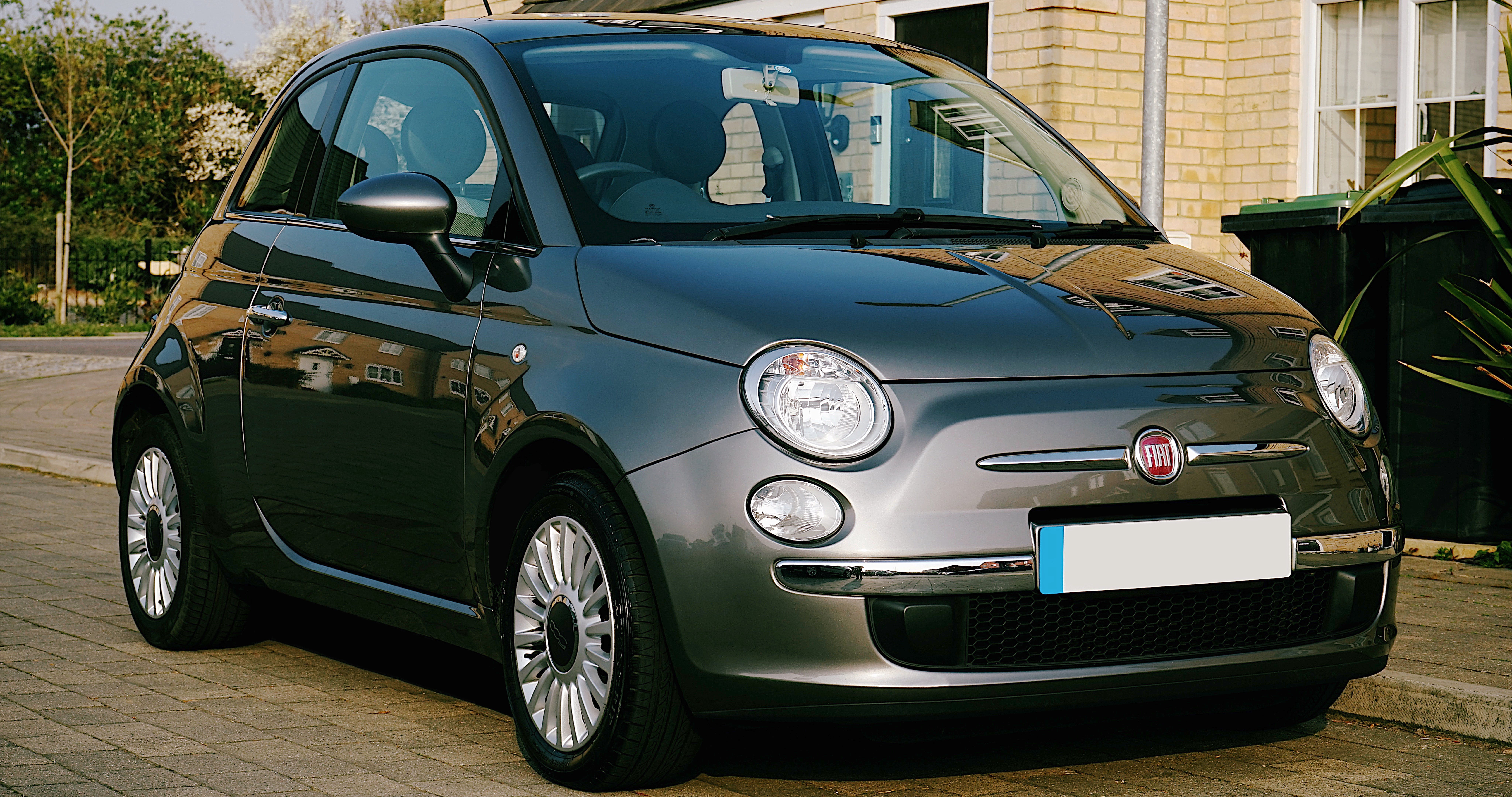A grey Fiat 500 sitting on a road