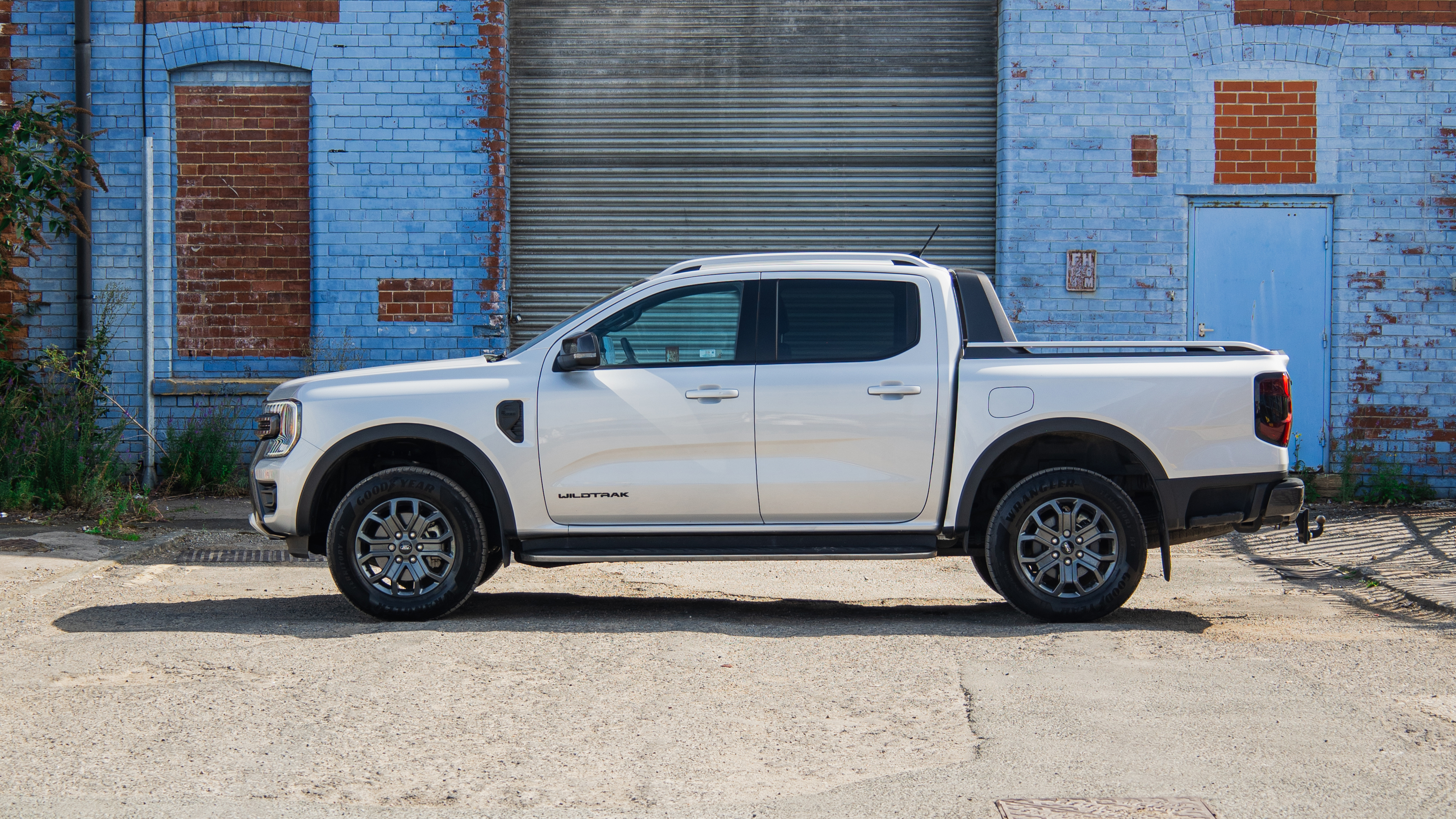 White Ford Ranger Wildtrak parked outside an old warehouse, showcasing a business lease pick-up from AMT Auto.
