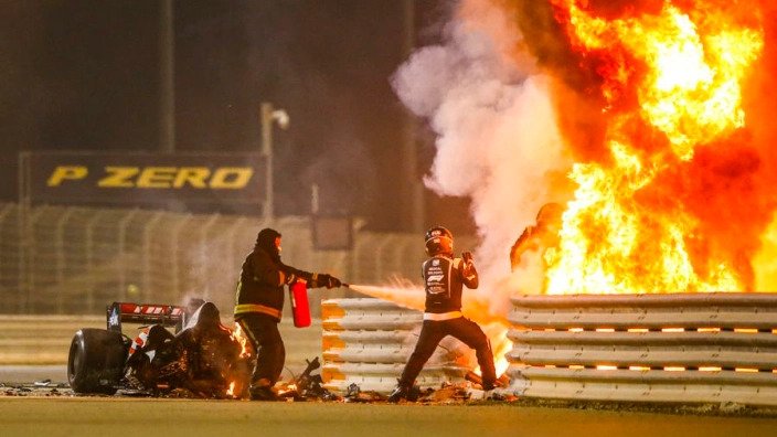 Romain Grosjean is seen being guided out of the fire by Dr Ian Roberts.