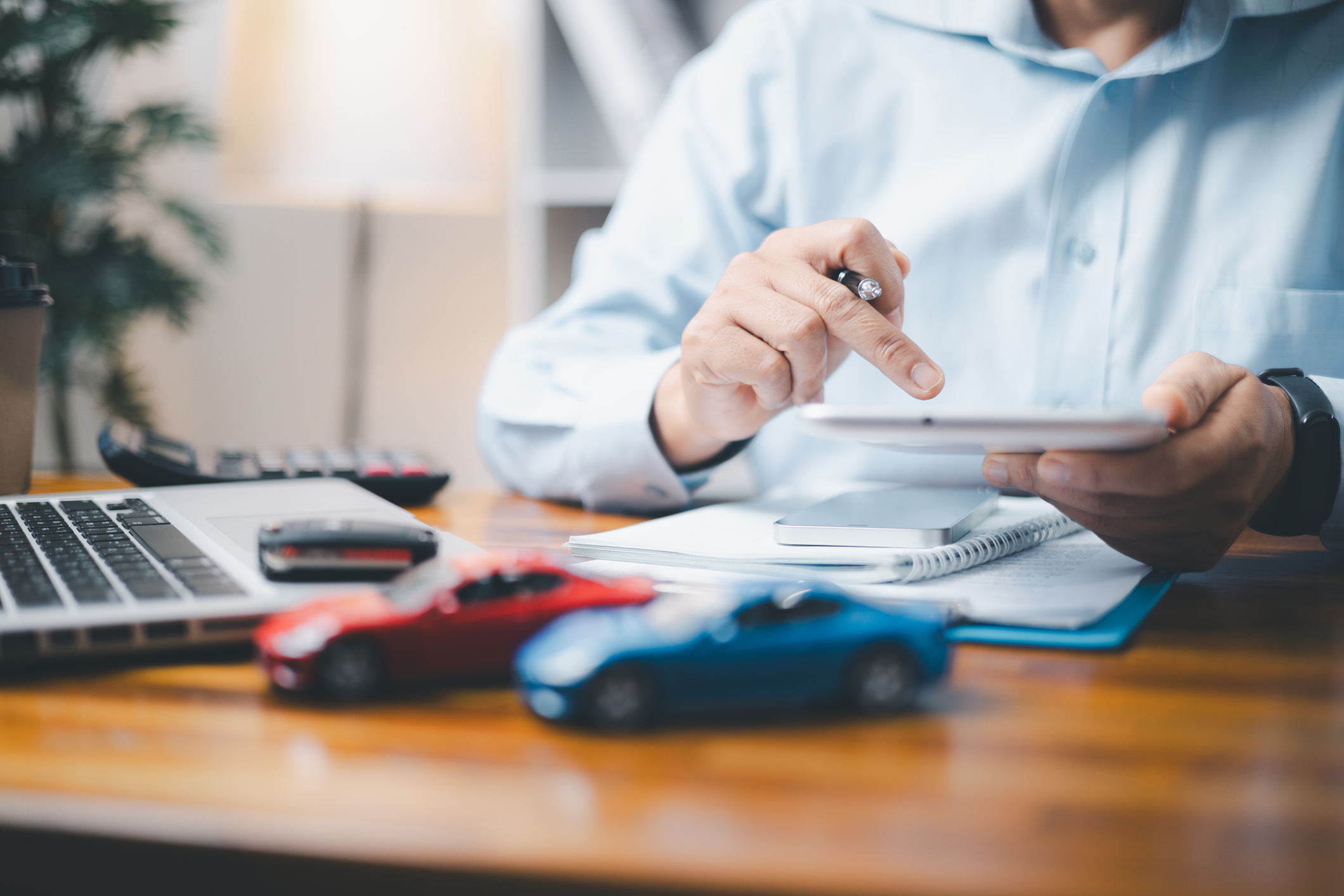 close up of businessman at desk with toy cars