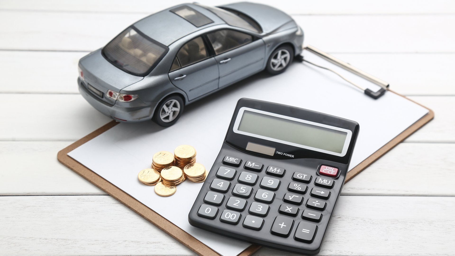 Calculator, coins and car model symbolising cheap car lease deals in the UK.