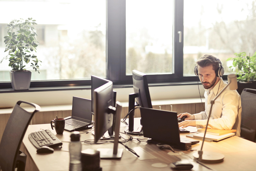 An image of a man in an office working and using the phone